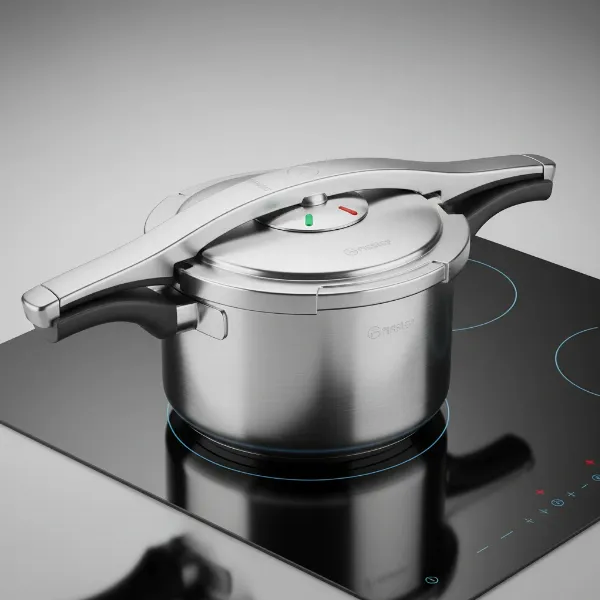 Fissler Vitaquick stainless steel pressure cooker on an induction stovetop, showcasing its sleek design and durable build.