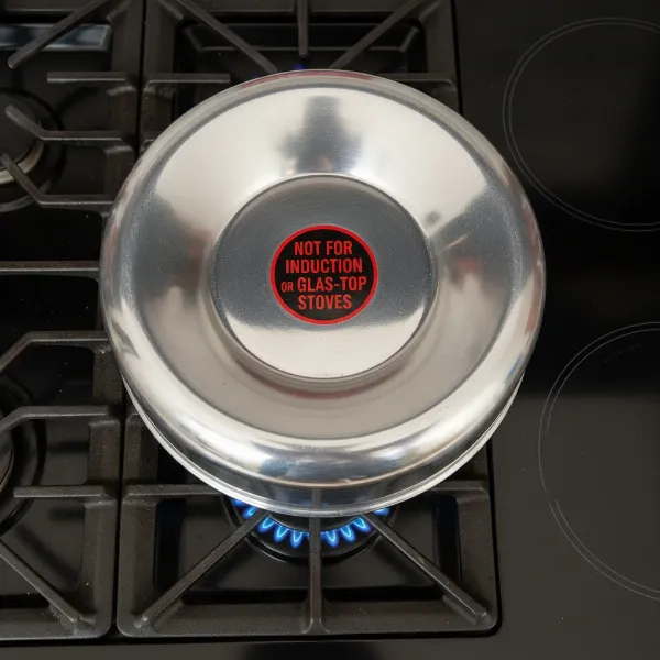 A Mirro polished aluminum pressure cooker with a concave base, explicitly showing its incompatibility with flat cooktops.