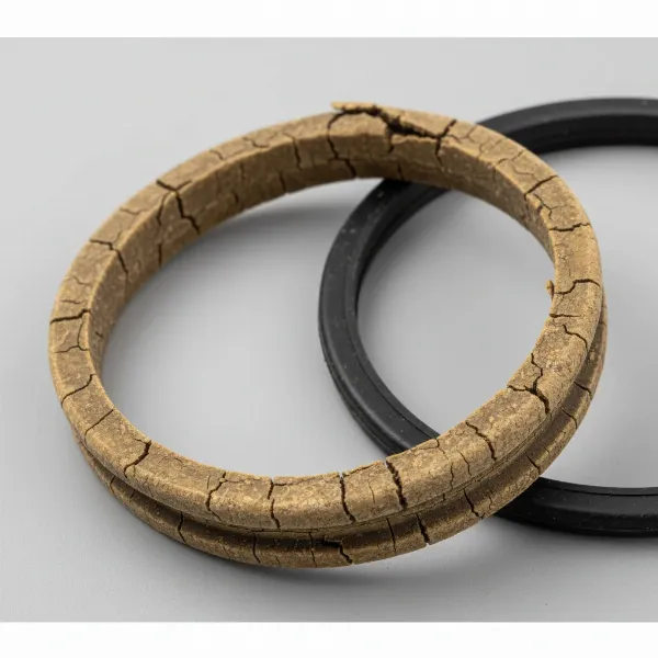 Close-up of a damaged pressure cooker gasket with visible cracks and brittleness.